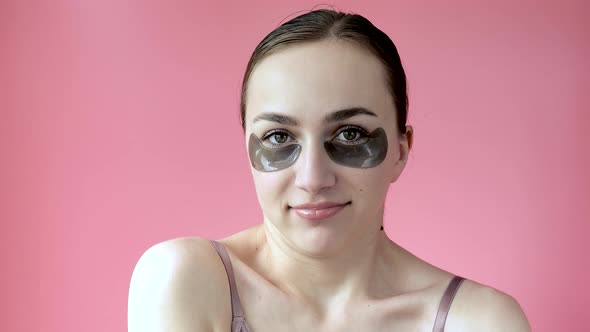 Head shot portrait close up smiling young woman with under eye moisturizing patches mask