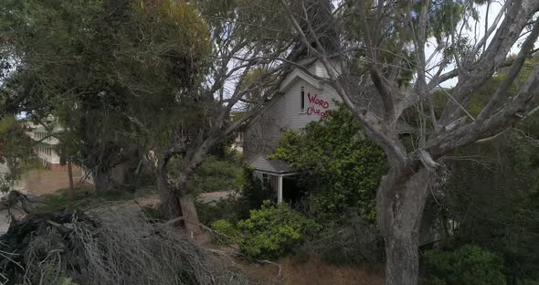 Slow Motion Aerial of Abandoned Overgrown Church hidden my trees Monterrey Fort Ord California