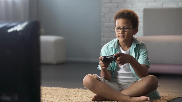 Afro-American Schoolboy Spending His Free Time Playing Games on Console, Leisure