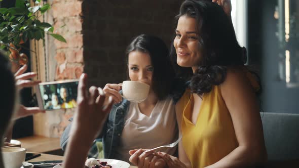 Pretty Ladies Drinking Coffee in Cafe and Taking Photos with Smartphone Laughing