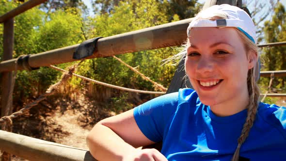 Happy woman standing near obstacle in boot camp