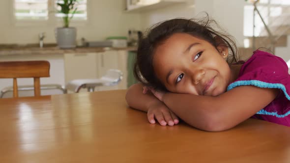 Portrait of happy hispanic girl relaxing lying on table