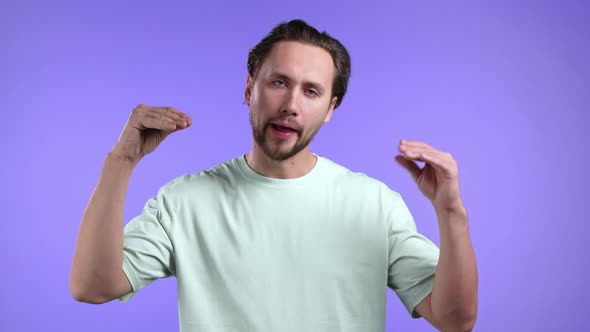 Handsome Bored Man Showing Blablabla Gesture with Hands and Rolling Eyes Isolated on Violet