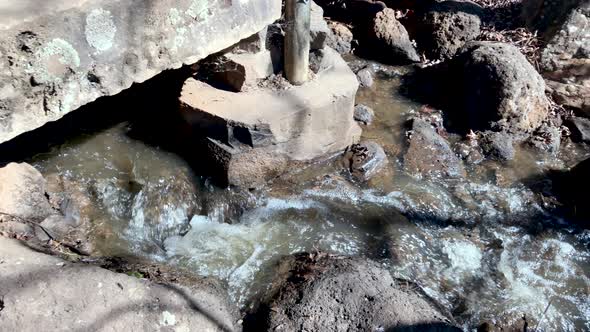 Pan follow of flowing creek water from waterfall to pond, Ju Raku En Japanese Garden, Toowoomba, Aus