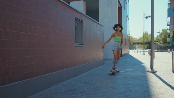 Beautiful young woman cruising around the city with her longboard.