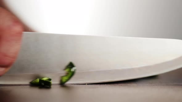 Professional chef chopping poblano pepper.