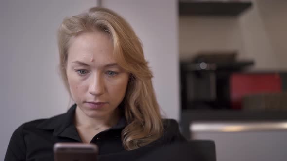 Handheld Shot of Blond Woman Sitting Texting on the Phone