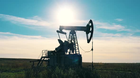 Working Oil Pump Jack at Work in the Oilfield. Oil Industry, Crude Oil Prices Concept.