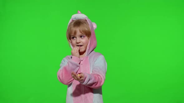 Little Child Smiling Enjoying Eating Sweets Candies Dessert in Unicorn Costume on Chroma Key