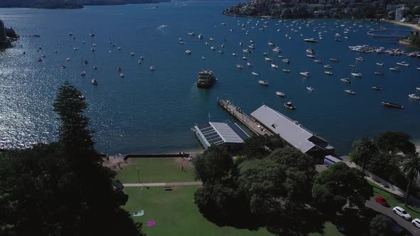 Sydney Harbor on a beautiful sunny day from Double Bay featuring boats, blue sky and water. Drone fl