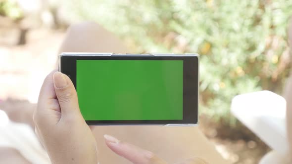 Woman relaxing on deck-chair with green screen tablet 4K 2160p 30fps UHD footage - Young female hold