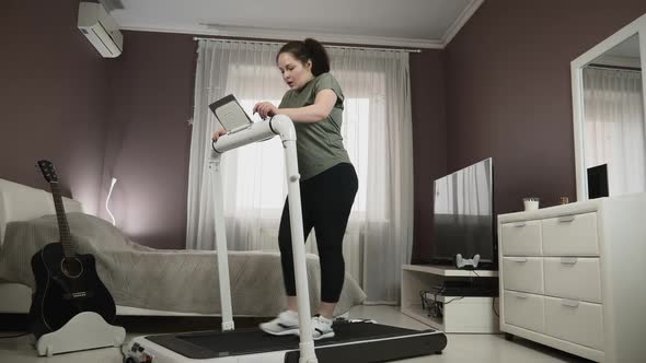 Tired young woman after workout on treadmill. 