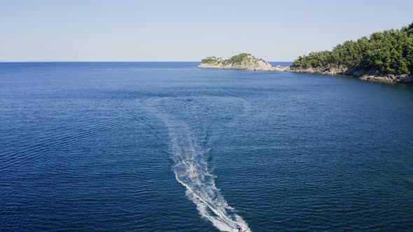 Drone view of kid doing water ski in the sea.