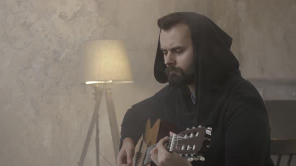 Young Man Playing Guitar in the Room