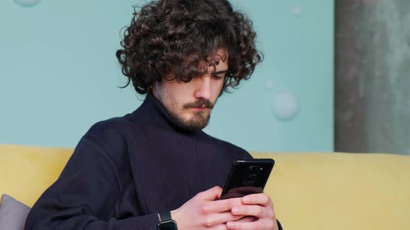 Man Holding Smartphone and Writing a Mail Chating in Social Media
