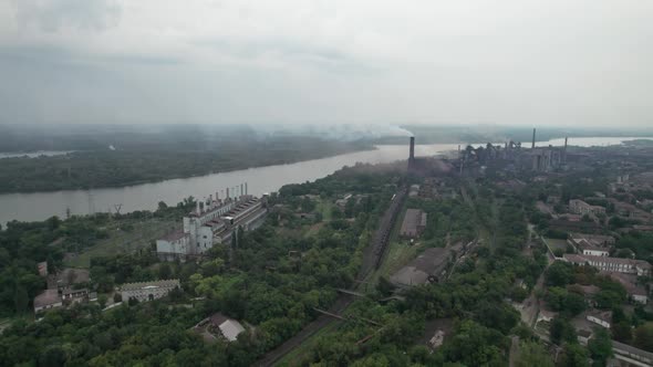 Aerial View of the City Near a Large Industrial Plant with Pipes and Smoke