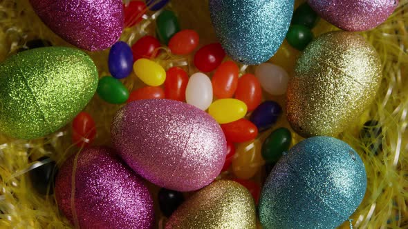 Rotating shot of Easter decorations and candy in colorful Easter grass 