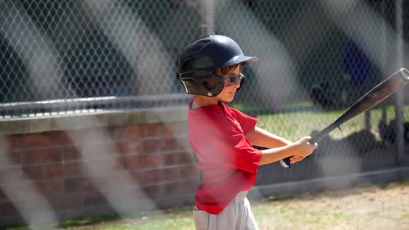 A boy is at bat while playing little league baseball.