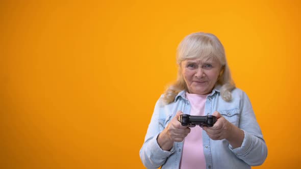 Active Optimistic Elderly Woman Playing Computer Game, Holding Joystick, Gadget