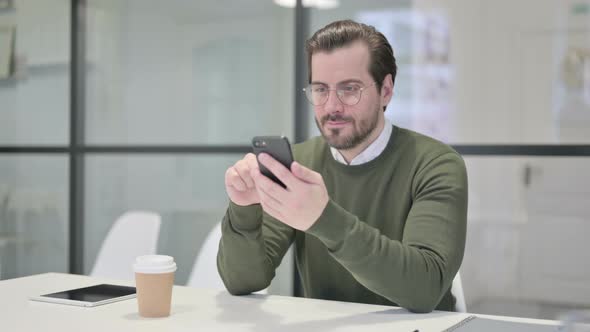 Successful Young Businessman Celebrating on Smartphone