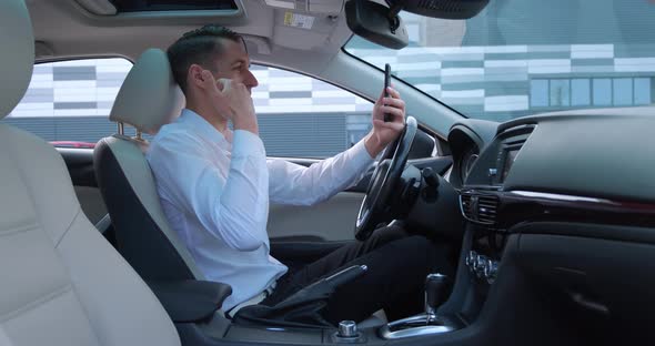 Young Businessman Having Video Chat Using Smartphone While Sitting in a Car