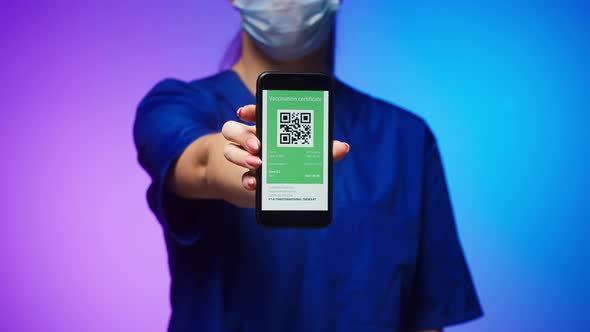 Woman Surgeon in Medical Uniform Showing Vaccination Passport with Qr Code on Phone International