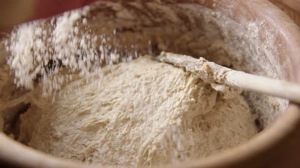 BAKING - Sprinkling flour over batter, sourdough bread, slow motion zoom in