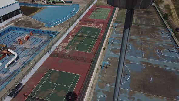 An aerial view of a tennis court which is abandoned. The shot has been captured by drone