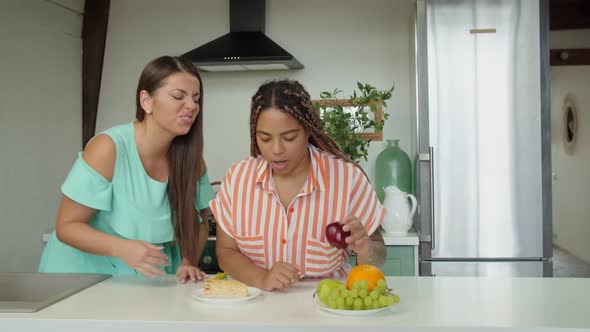 Black Young Woman Choosing Healthy Food or Junk to Eat in Kitchen