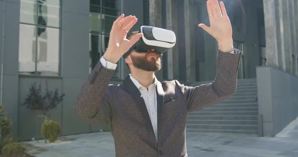 Businessman Standing Near Modern Urban Building and Working in Virtual Reality headset