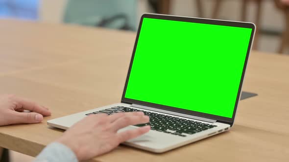 Creative Young Man Using Laptop with Chroma Screen