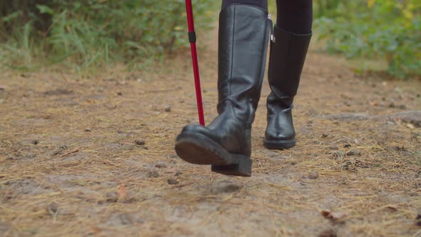 Female in Boots with Trekking Poles Hiking on Path