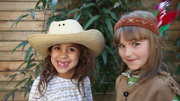 Two girls dressed as cowgirl and Native American