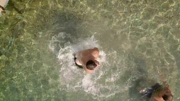 Aerial view of a young man jumping in the sea on a beach in Rodini.