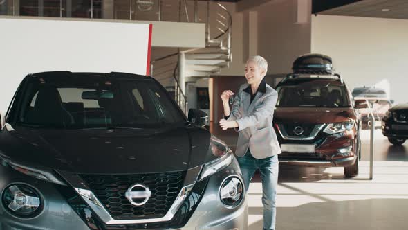 Adult Blond Woman Receiving Keys of Her New Car Photo of Laughing Caucasian