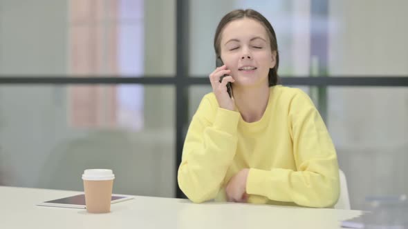Young Woman Talking on Smartphone in Office