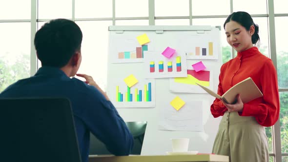 Young Woman Explains Business Data on White Board
