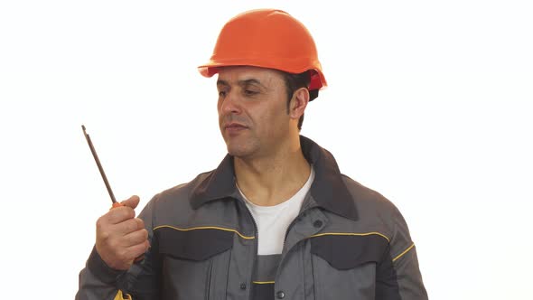 Mature Repairman Choosing Between Screwdriver and Drilling Machine