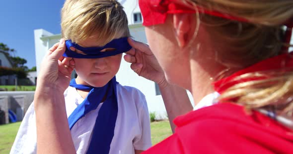 Mother adjusting mask of her son in garden 4k