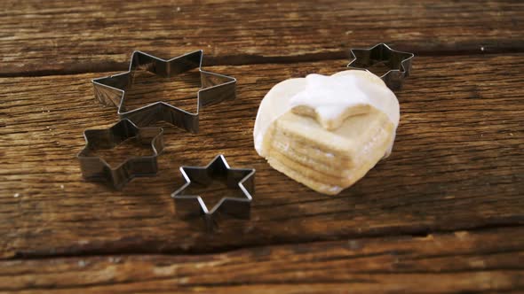 Cookie cutter and cookie on wooden plank