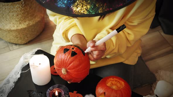 Girl painting pumpkin for Halloween