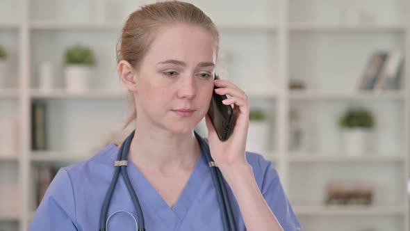 Professional Young Female Doctor Talking on Smartphone