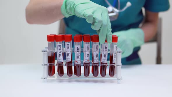 Doctor Nurse Woman Wearing Protective Mask and Latex Gloves - Working with Blood Test Tube Rack