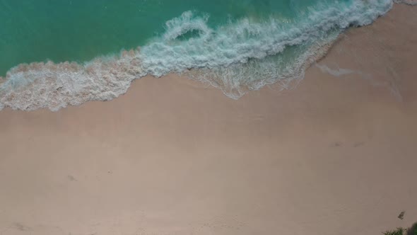 Slow Motion Top View of Sea Foamy Splashing Waves on a White Sand Beach