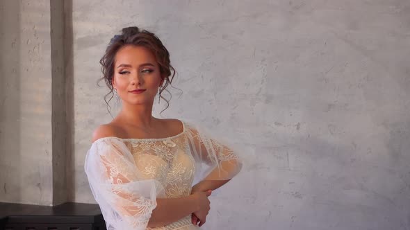 Happy Girl in White Dress Smiles and Professionally Poses for the Photographer