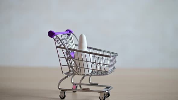 The Pharmacist in the Seals Fills a Mini Shopping Cart with Various Medicines for a Viral