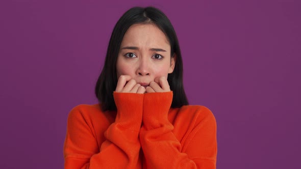 Frightened woman covering her eyes with her hands