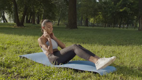 Sporty Fit Female Exercising Sit-ups Outdoors