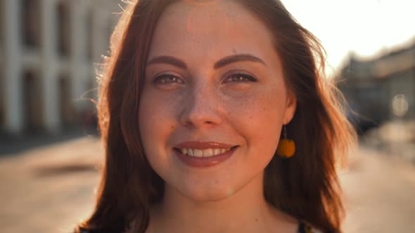 Cute Girl with Red Hair and Freckles on the Street. Big City Central Street. Sunrise Lighting.