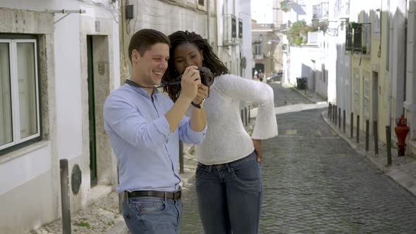Happy Interracial Couple of Tourists Standing in Old City Street